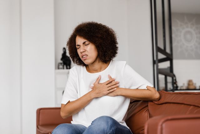 Journée mondiale du cœur : comment prévenir les maladies cardio-vasculaires chez la femme ? Image d'une femme qui se tient le cœur et grimace de douleur.