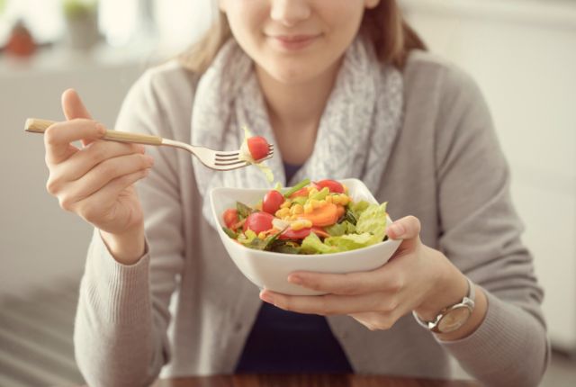 Semaine de la dénutrition en novembre 2024 : ELSAN sensibilise le grand public. Image d'une femme en train de manger une salade composée de tomates cerises, de maïs et de laitue.