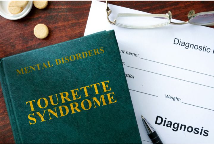 Syndrome gilles de la Tourette : un ouvrage en anglais faisant référence à ce syndrome, posé sur une feuille de diagnostic.